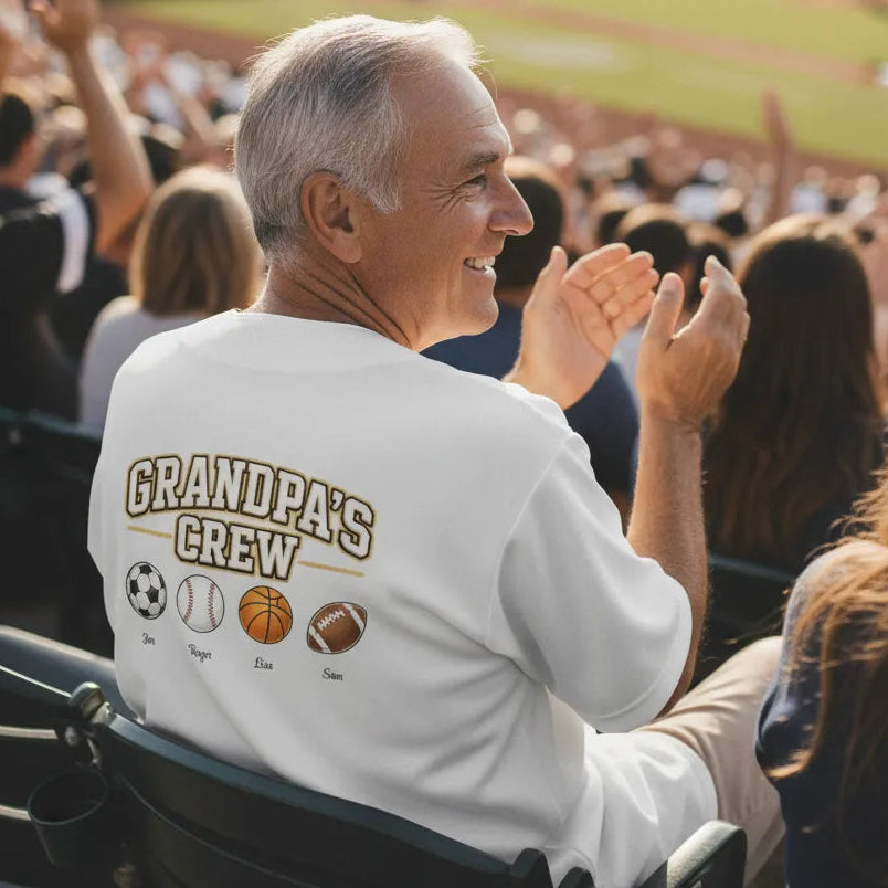 Personalized Grandpa's (or Grandma's) Team Embroidered Baseball Jersey Man in a 'Grandpa's Crew' shirt at a sports event clapping and smiling.