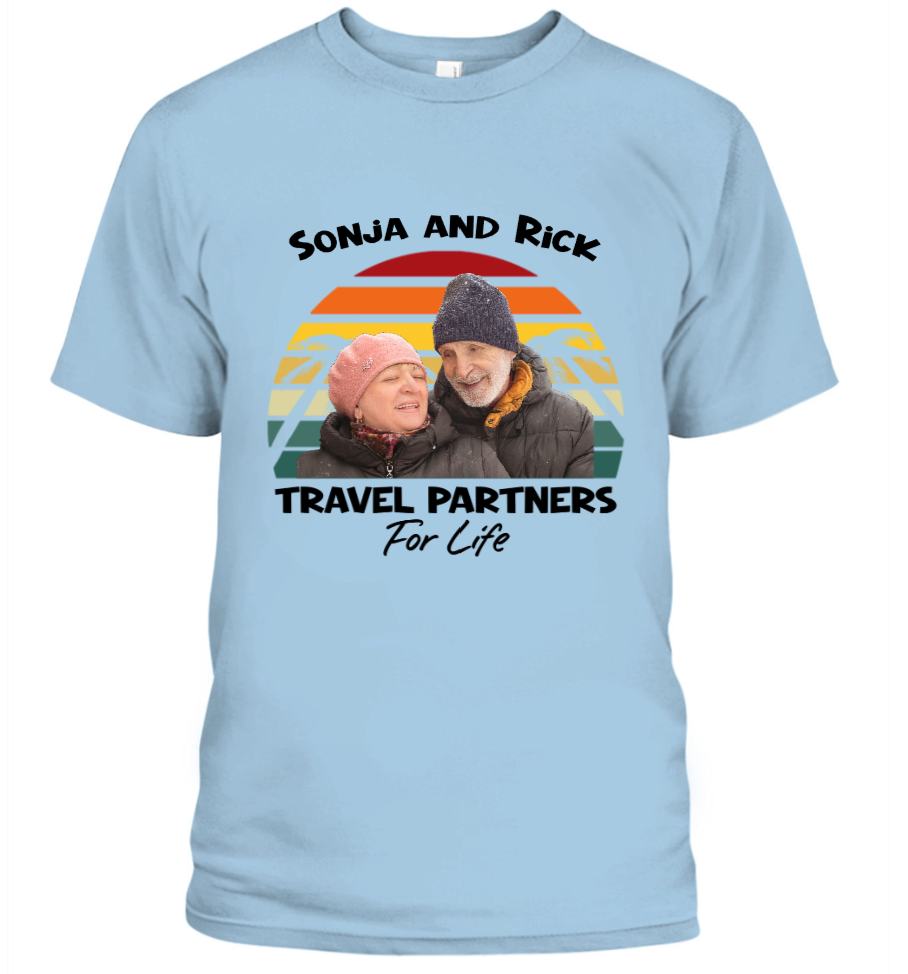 Light blue t-shirt with a graphic of two people and text 'Sonja and Rick Travel Partners For Life' on a white background.