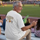 Man sitting on bleachers at a sports event, wearing a 'Grandpa's Crew' Custom Embroidered Baseball shirt. Love Life Journey