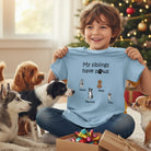 Child holding a shirt Custom dog lover kids shirt with up to four personalized dogs and names surrounded by dogs in a festive room.