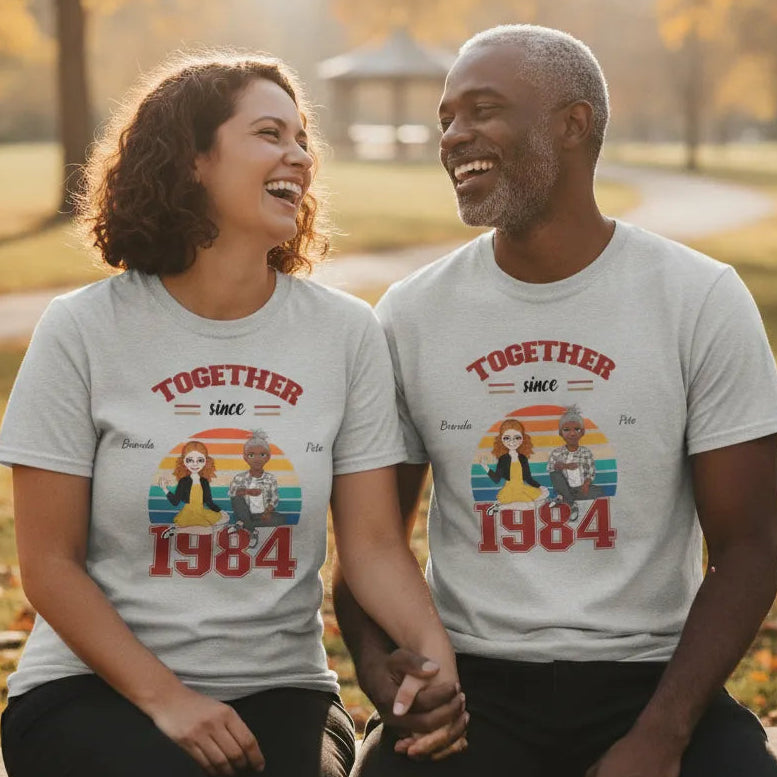 Couple wearing personalized Together Since shirts celebrating their love story. 'Together Since 1984' t-shirts in a park setting.