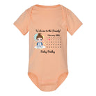 Custom newborn baby bodysuit with personalized birth date, arrival calendar, and family welcome message Peach-colored baby onesie with a printed design on a white background 