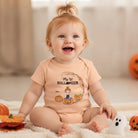 Baby wearing personalized Halloween bodysuit with custom name and pumpkin-themed design